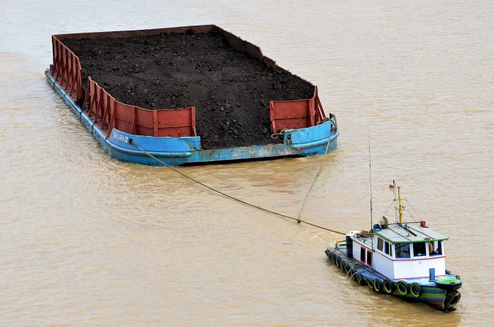 Kapal Tongkang pembawa batubara melintasi aliran Sungai Batanghari di Muarojambi, Jambi.